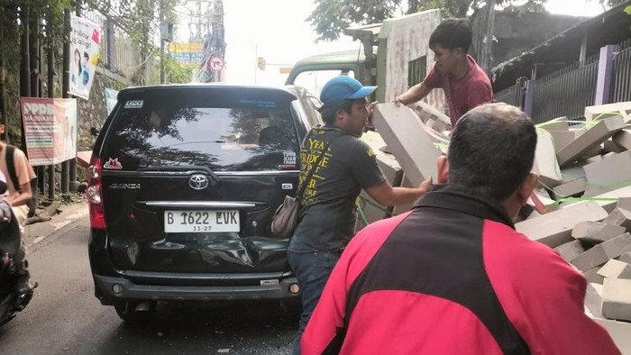 Truk Hebel Terbalik di Sawangan, Timpa Satu Mobil