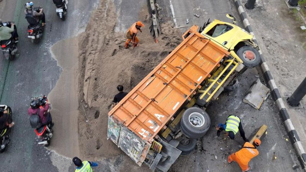 Sopir Mengantuk, Truk Muatan Pasir Terguling di Gatot Subroto