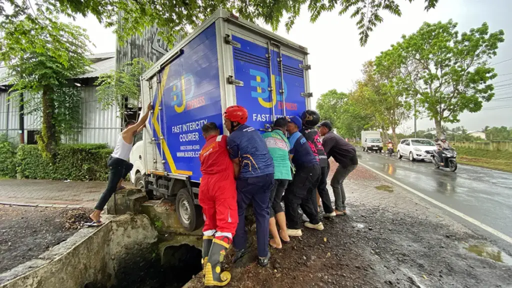 Tak Bisa Ditarik, Damkar dan Warga Kompak Angkat Pikap yang Terjebak di Kanal